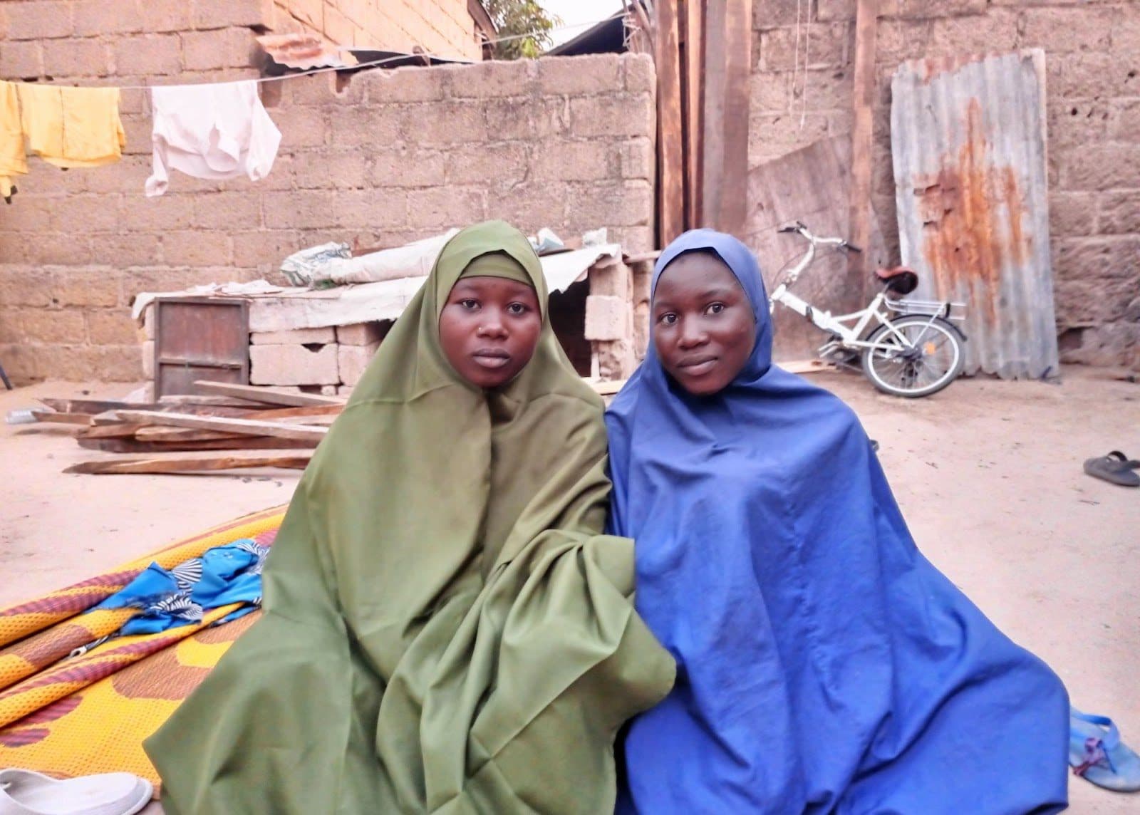 Zarah Adamu (in blue) and her sister in their home in the London Ciki community of Borno State. Photo: Al’amin Umar/HumAngle.
