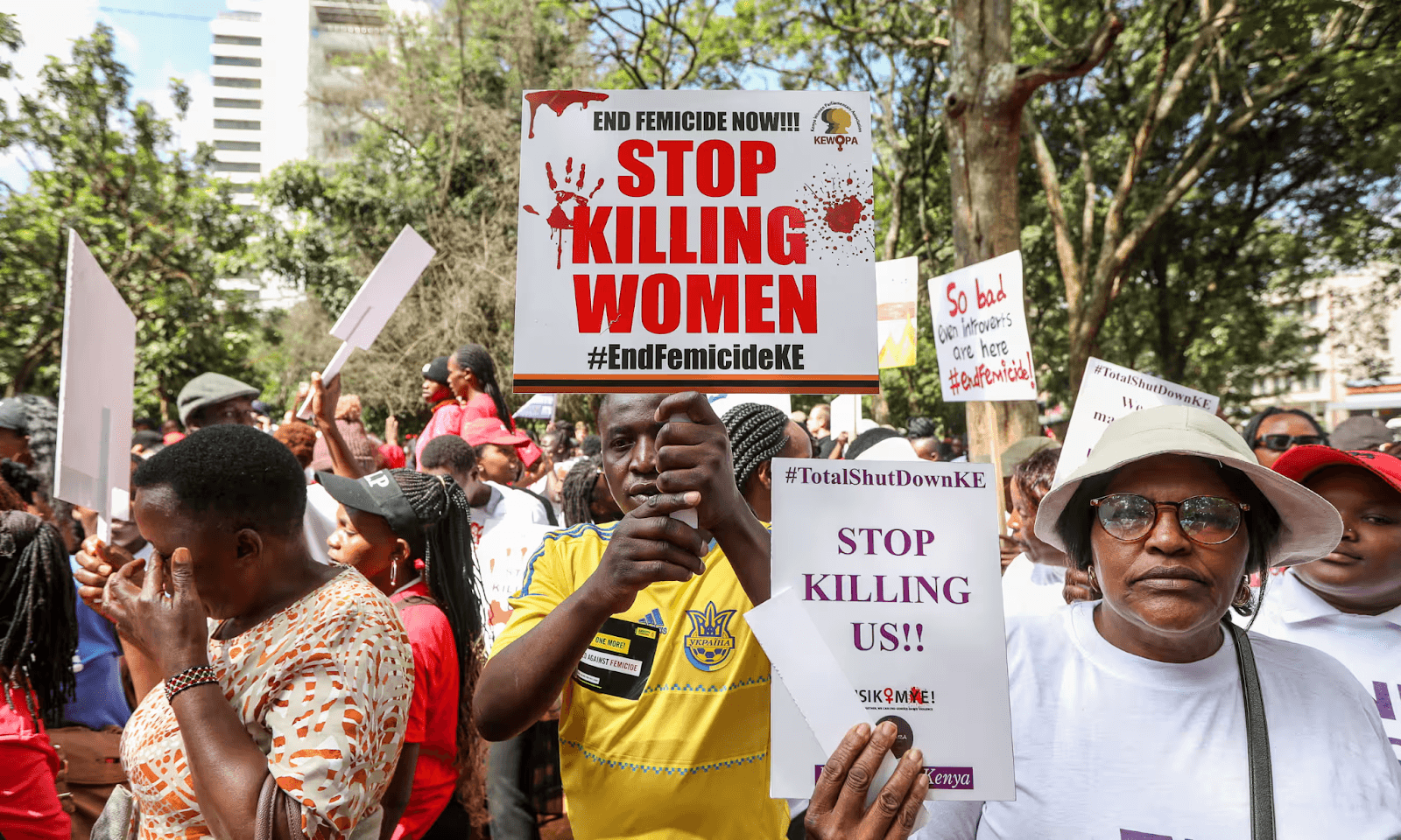 Protestors holding signs against femicide, advocating to stop violence against women. #EndFemicideKE