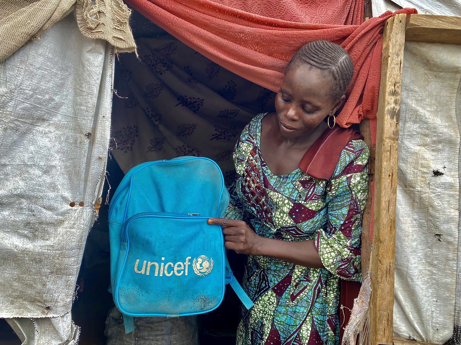 Yana shows her child’s school bag. He has stopped using it since their camp was shut down in 2022.