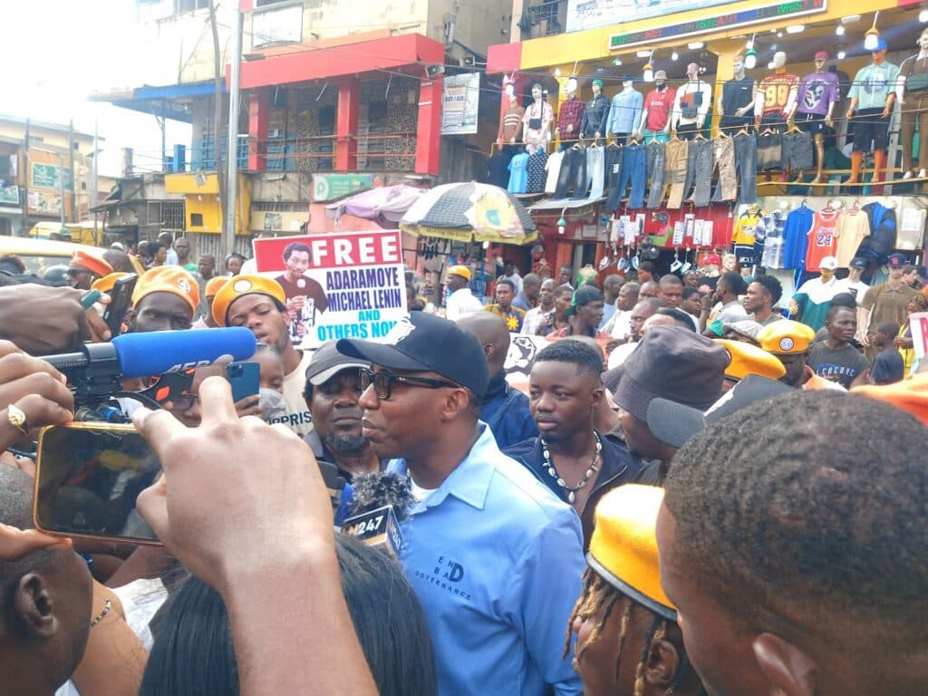 Crowd of people at a protest with signs and megaphones.