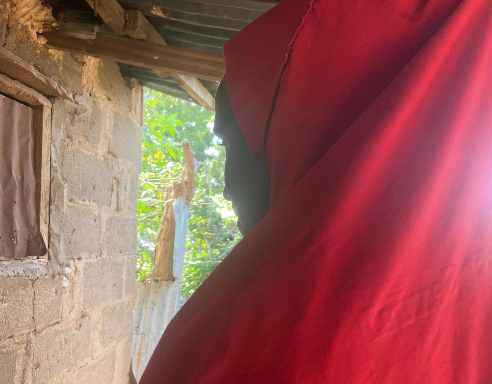 Side profile of Asabe, wearing a red hijab