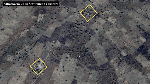 Aerial view of Mbadwem 2014 settlement clusters, highlighting two areas with yellow squares. Sparse vegetation and fields visible.