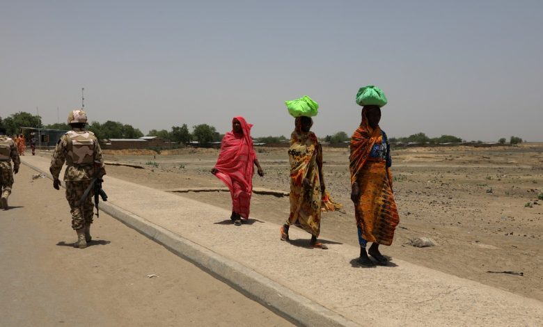 Women walk past soldiers on a bridge separating Cameroon and Nigeria in Gamboru Ngala, Borno State, in April, 2017. Photo: Afolabi Sotunde/Reuters