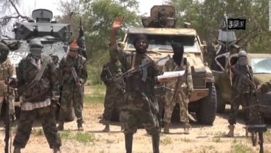 Leader of Boko Haram, Abubakar Shekau speaking in front of armoured vehicles