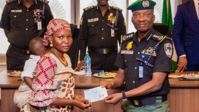 Acting Inspector-General of Police (IGP), Olukayode Egbetokun presenting a cheque to the widow of a slain officer.