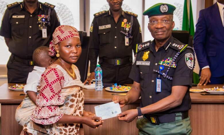 Acting Inspector-General of Police (IGP), Olukayode Egbetokun presenting a cheque to the widow of a slain officer.