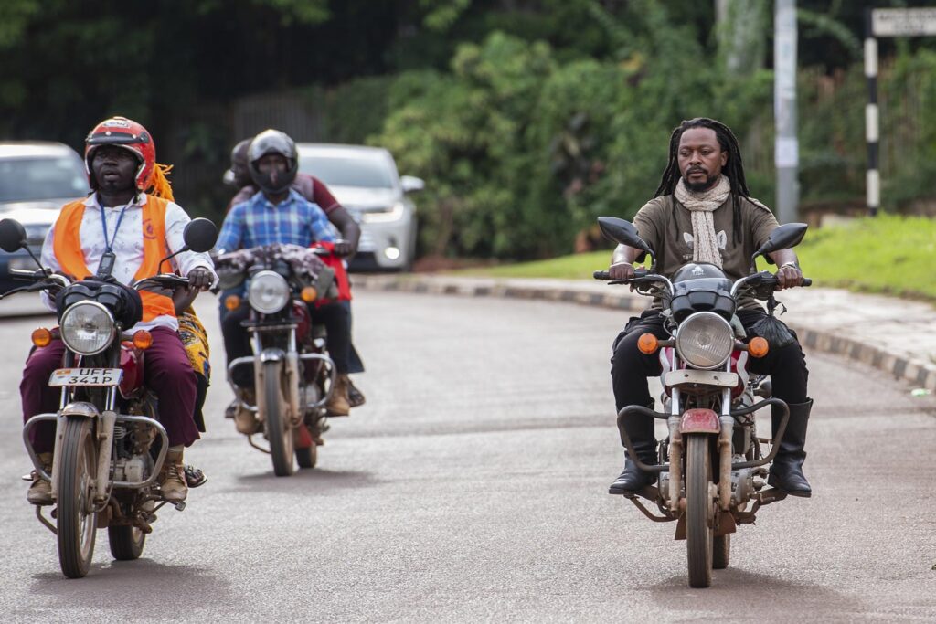 A boda boda rider, a commercial motorcycle driver, rides on the streets of Kampala, Uganda 27 October 2023. Photograph by Nicholas Bamulanzeki / CCIJ