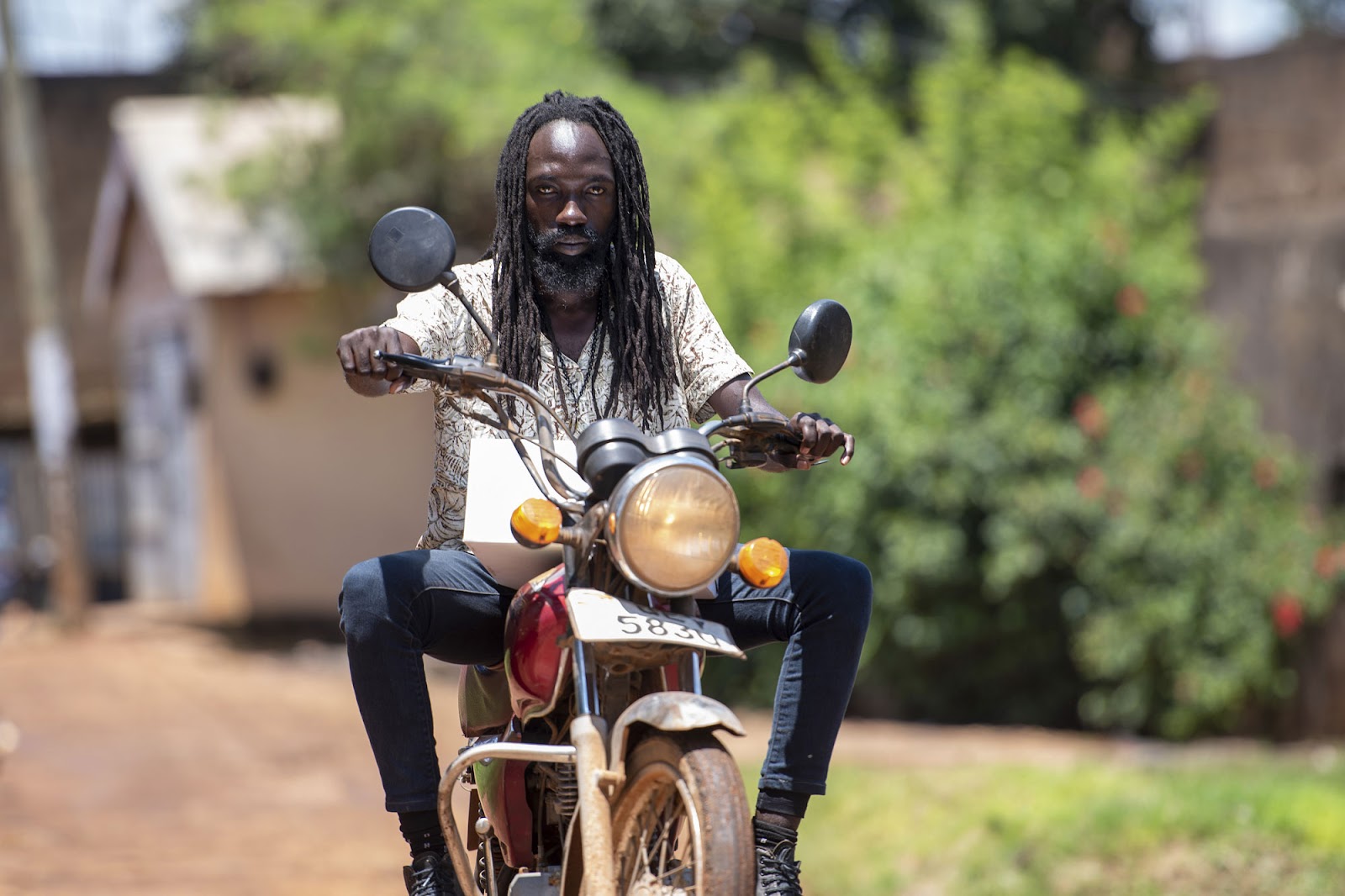 Ivan Lubulwa, also referred to as Dogota, rides his bike in Kampala, Uganda. He has worn dreadlocks since 2017 and works as a boda boda rider, a commercial motorcycle driver. Kampala, Uganda 23 October 2023. Photograph by Nicholas Bamulanzeki / CCIJ