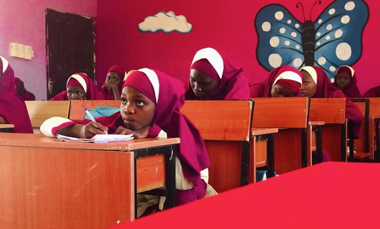 A group of girls sitting at desks in a classroom.