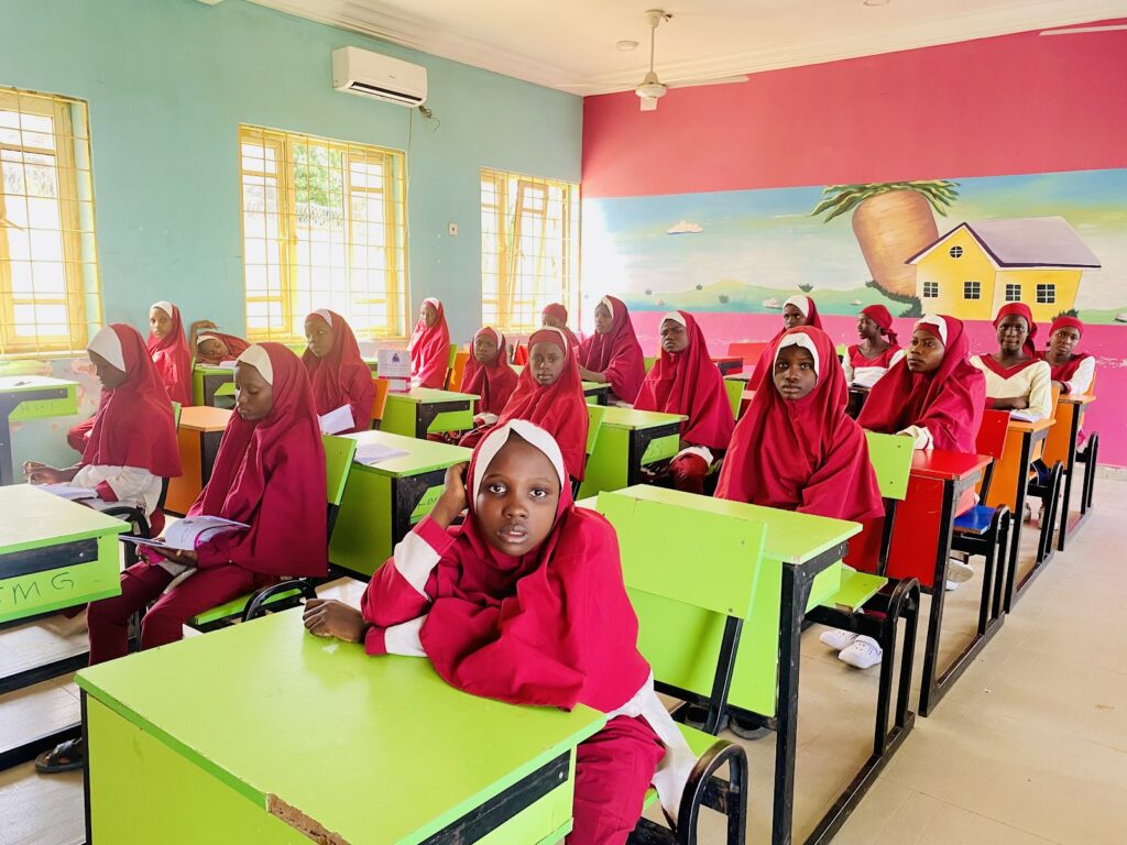 A group of girls sitting at desks in a classroom.