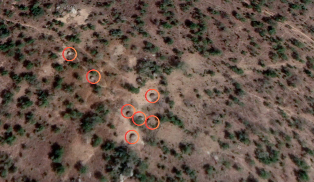 Aerial view of a scrubland with several spots encircled in red.