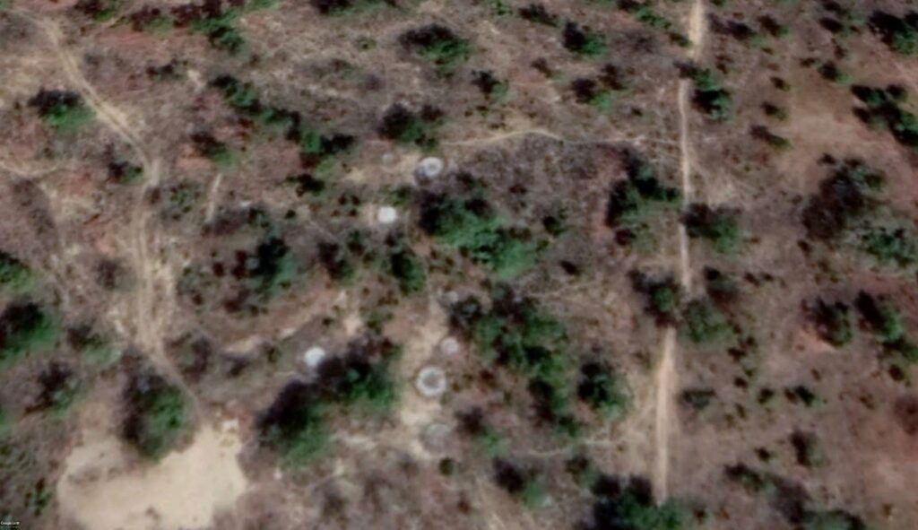 Aerial view of a dry landscape with sparse vegetation and dirt trails.