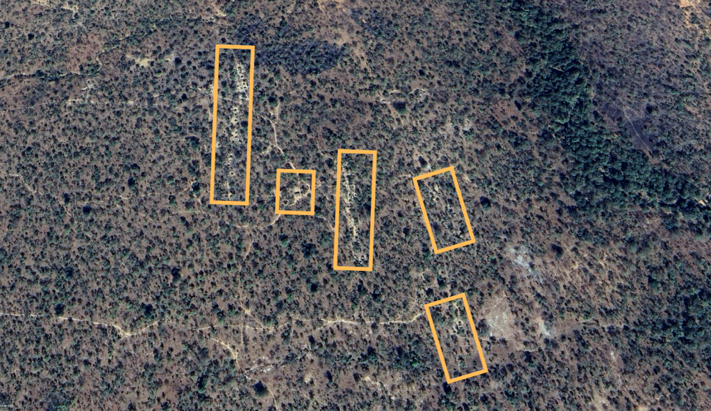 Aerial view of a landscape with marked areas outlined in orange.