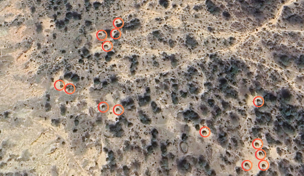 Aerial view of a barren landscape with multiple red circles marking specific points.