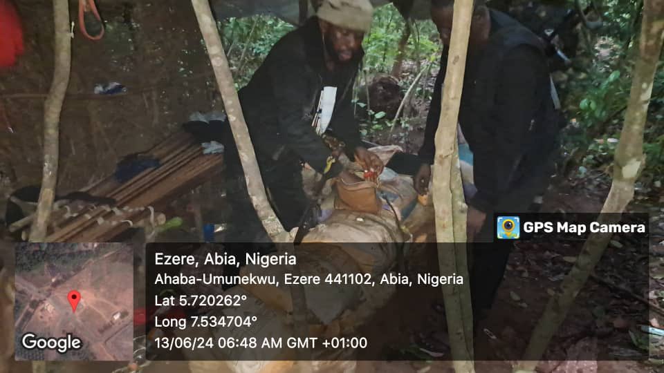 People working in a forest at night with location details from Ezere, Abia, Nigeria displayed on the image.