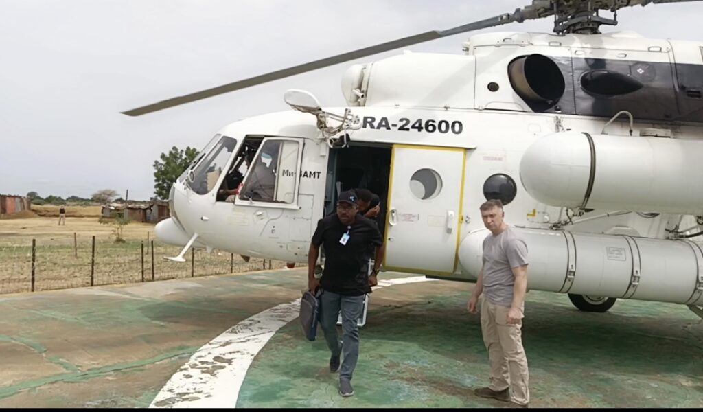 People disembarking from a white helicopter with registration number RA-24600 on a helipad.