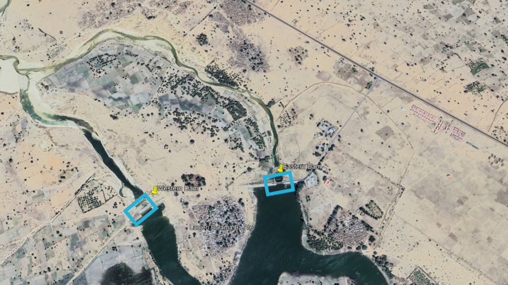 A satellite image depicting a river, two dams with labels, and surrounding arid landscape with patches of vegetation.