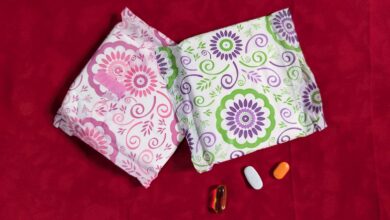 Two patterned tissue packages and three pills on a red background.