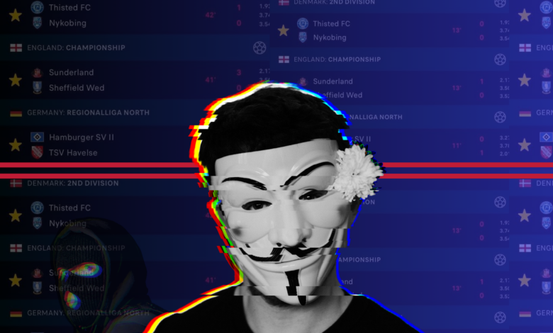 Person wearing a Guy Fawkes mask with a glitch effect and football match scores in the background.