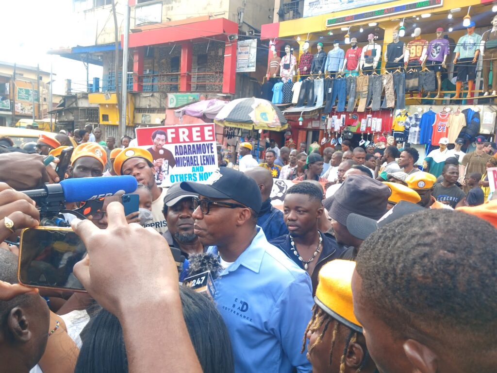 Crowd of people at a protest with signs and megaphones.