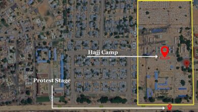 Satellite view of an urban area with labeled locations: Hajj Camp, Protest Stage, and a mosque.