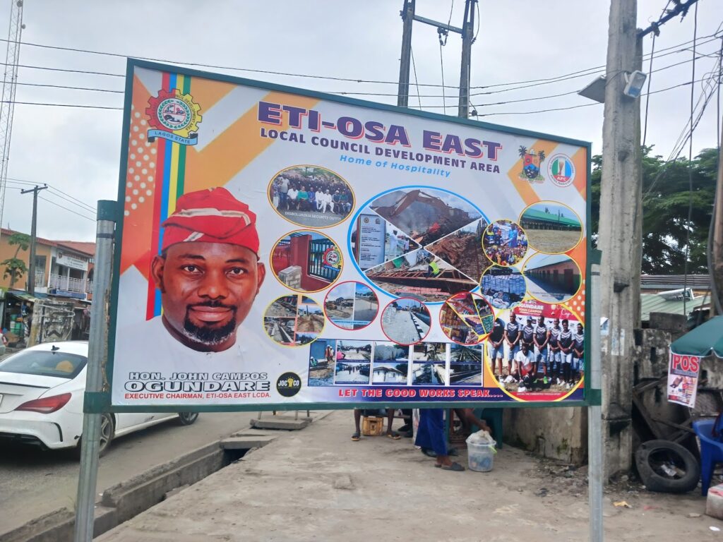 Billboard showing a man's portrait, community images, and texts relating to Eti-Osa East Local Council in Lagos.