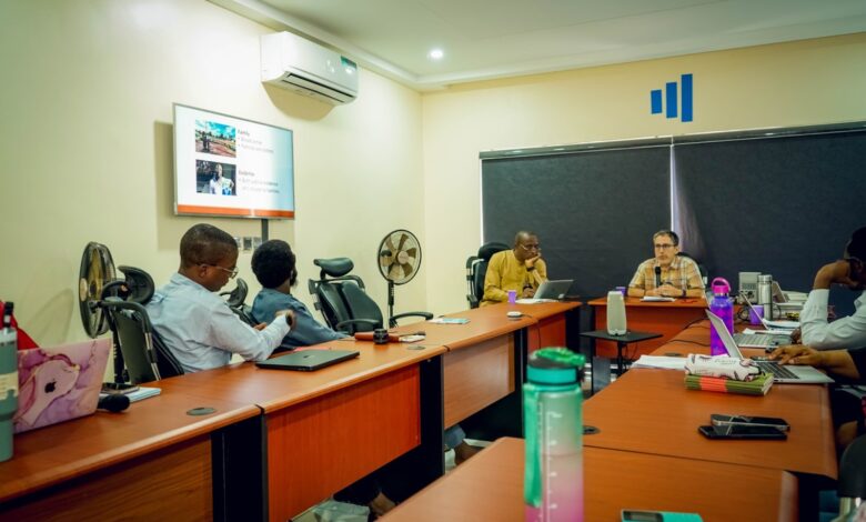 Professionals in a meeting room with a presentation on the screen.