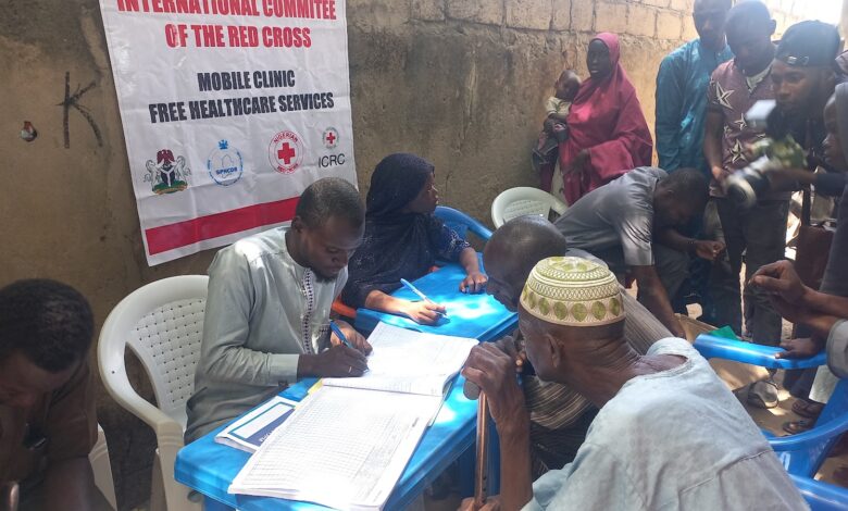 People registering at an ICRC mobile clinic for free healthcare services.