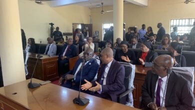 A courtroom scene with attendees seated, some listening intently with focused expressions.