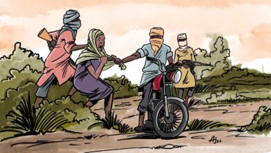 Cartoon of three people pushing a motorcycle on a dirt road, one carrying a jug, suggesting a rural setting.