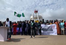 A group of people at a protest with banners advocating against bad governance in Nigeria.