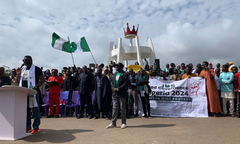 A group of people at a protest with banners advocating against bad governance in Nigeria.