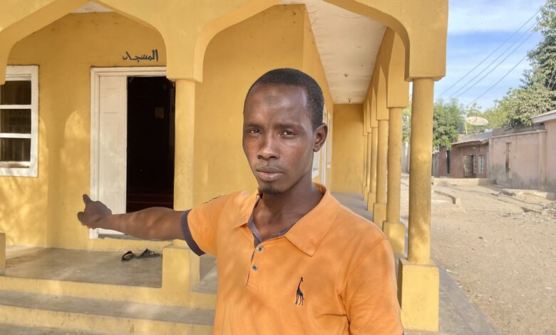 A man pointing at a mosque