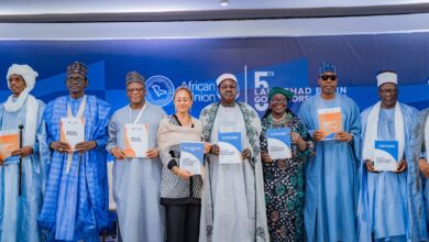 A group of individuals stands holding policy documents at the 5th Lake Chad Basin Governors Forum, African Union backdrop visible.