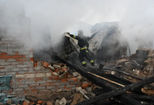 Firefighter amidst smoke, navigating through the debris of a damaged building.