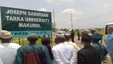 People gathered around the Joseph Sarwuan Tarka University Makurdi sign.