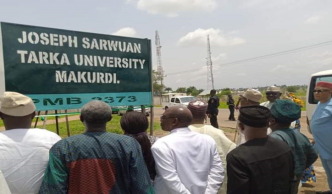 People gathered around the Joseph Sarwuan Tarka University Makurdi sign.