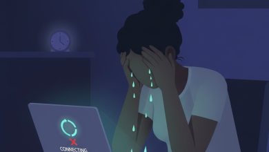 Person sitting at a table, laptop screen showing "connecting" message, holding head in frustration with tears falling.