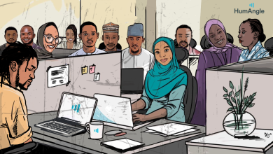 Illustrated office scene with diverse individuals at desks, some smiling and one working on a laptop, with the HumAngle logo visible.