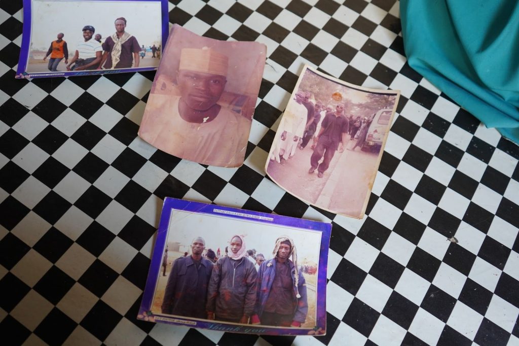 Old photographs on a black-and-white checkered floor, showing various people in group and individual portraits.