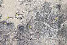 Satellite view of Tamanrasset, Algeria, showing labeled mines and a mining complex in the surrounding desert area.